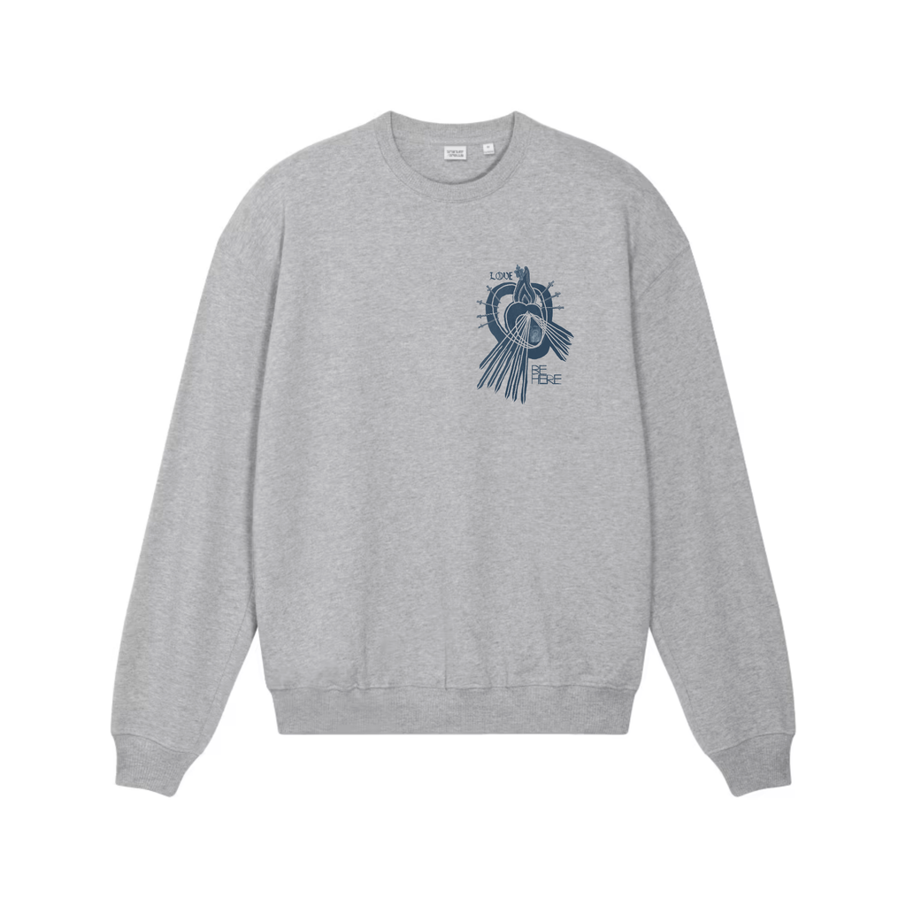 A heather gray crewneck sweatshirt shown from the front, featuring an indigo blue graphic print of a little human heart enclosed in the womb of the Sacred Divine Mercy Heart of Jesus enclosed in the womb of Immaculate Sorrowful Heart of Mary with the words LOVE and BE HERE